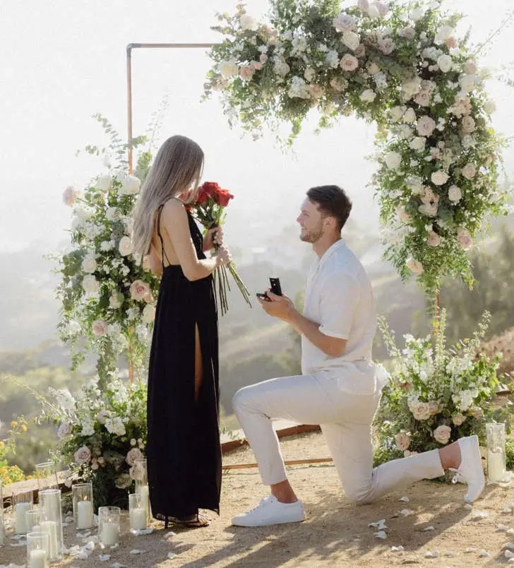 Kyle proposed to his girlfriend, Summer in front of a flower arch.