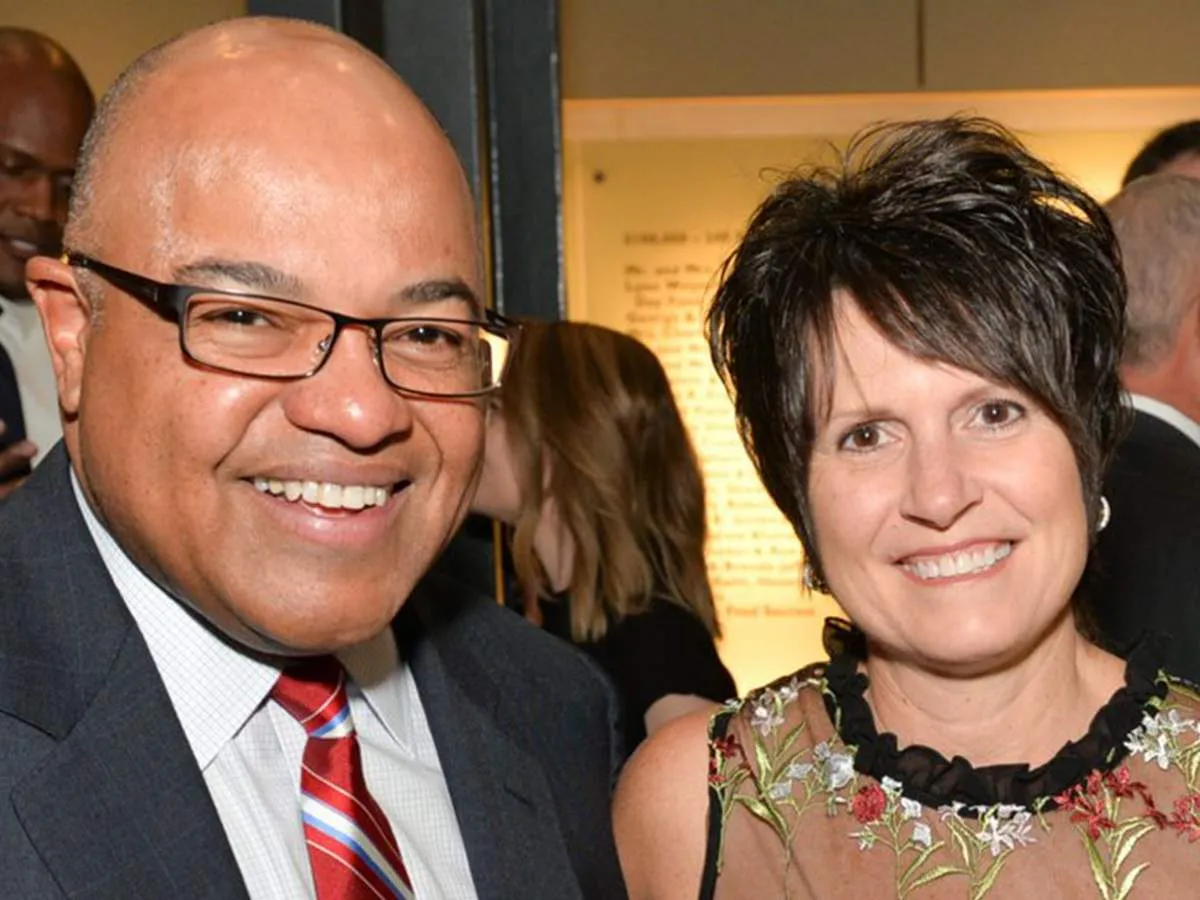 Mike Tirico and wife Debbie Tirico together in a frame.