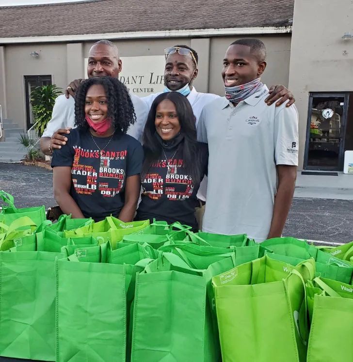 Derrick Brooks and his wife, Carol Brooks, distributing meals, with his brothers